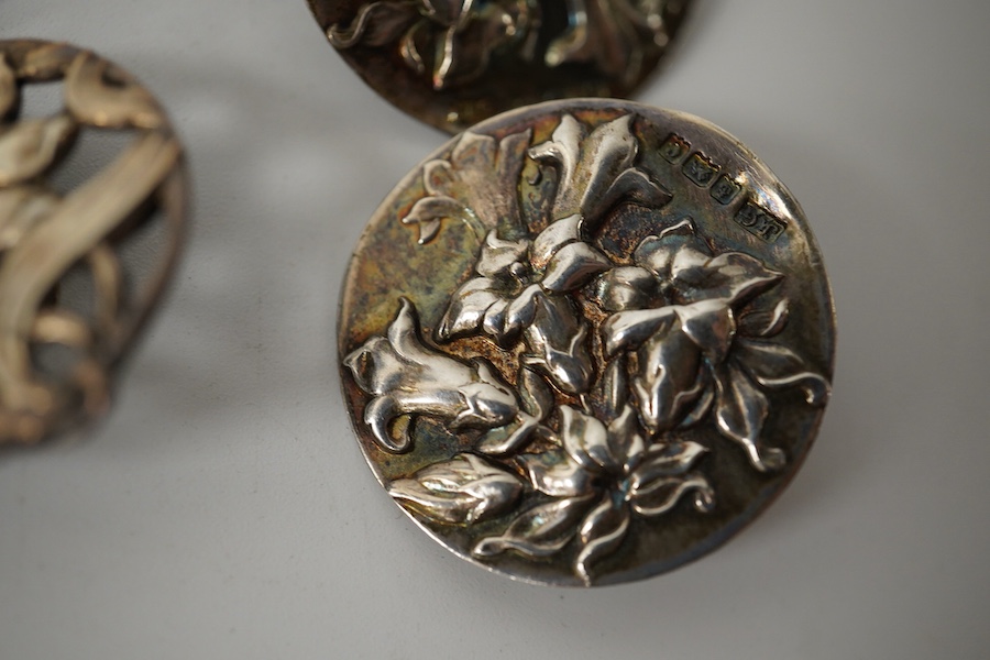 A pair of Art Nouveau enamelled white metal buttons, 33mm, a set of 3 cast silver flower buttons, H.C. Birmingham 1911, 23mm, a pair of silver lily pattern buttons, J.G. Birmingham 1903, 27mm and a pair of cast silver Ar